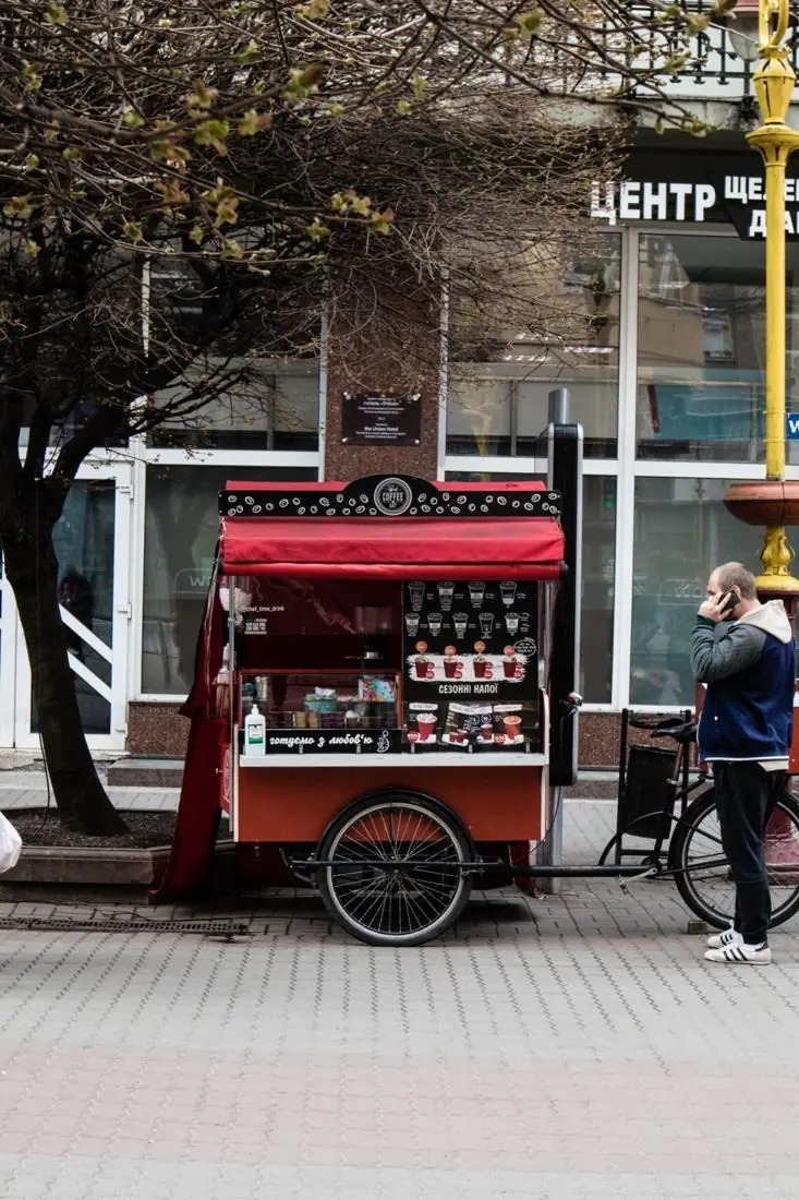 Rotes Kaffeefahrrad mit Theke in einer Fußgängerzone